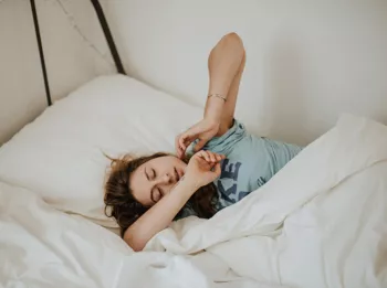 Woman Stretching While Laying in Bed